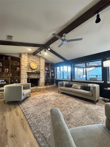 a living room with fireplace furniture and a large window