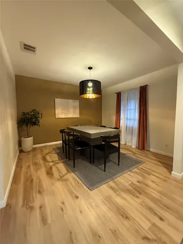 a living room with a table chairs and a wooden floor