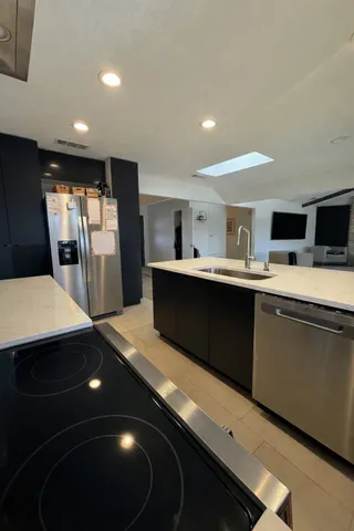 a kitchen with stainless steel appliances a sink stove and refrigerator