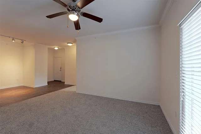 an empty room with ceiling fan and window