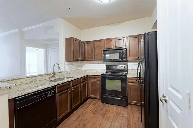 a kitchen with stainless steel appliances granite countertop a sink stove and refrigerator