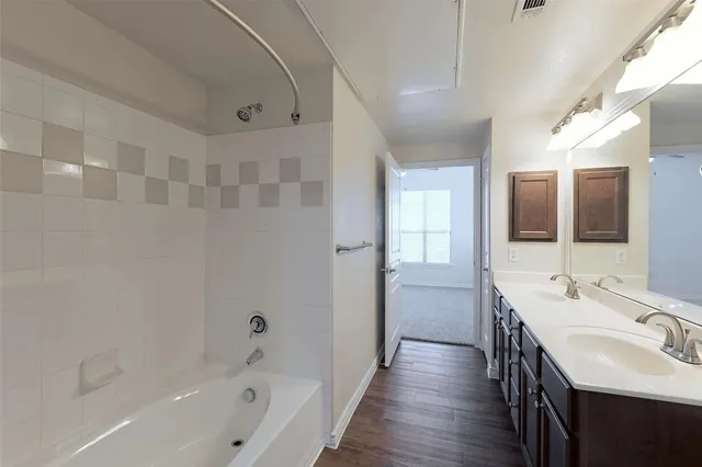 a bathroom with a tub sink shower and mirror