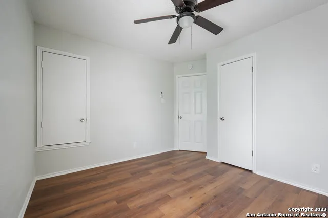a view of a room with wooden floor and ceiling fan