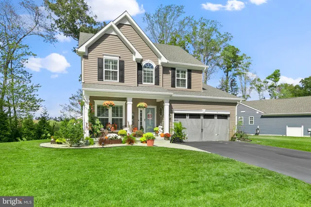a front view of a house with a garden and plants