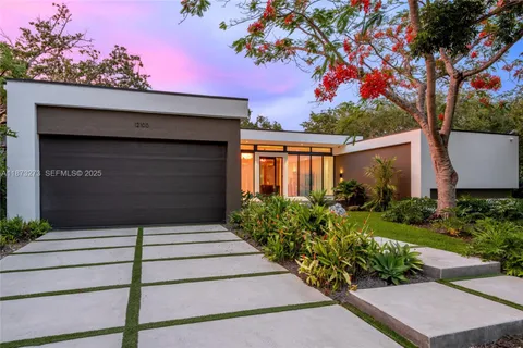 a front view of a house with a tree