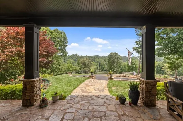 a view of a porch with a table chairs and a floor to ceiling window