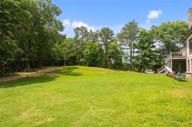 an aerial view of a house with outdoor space and trees all around