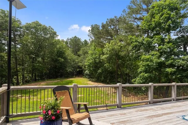 a view of a swimming pool with a yard and large trees