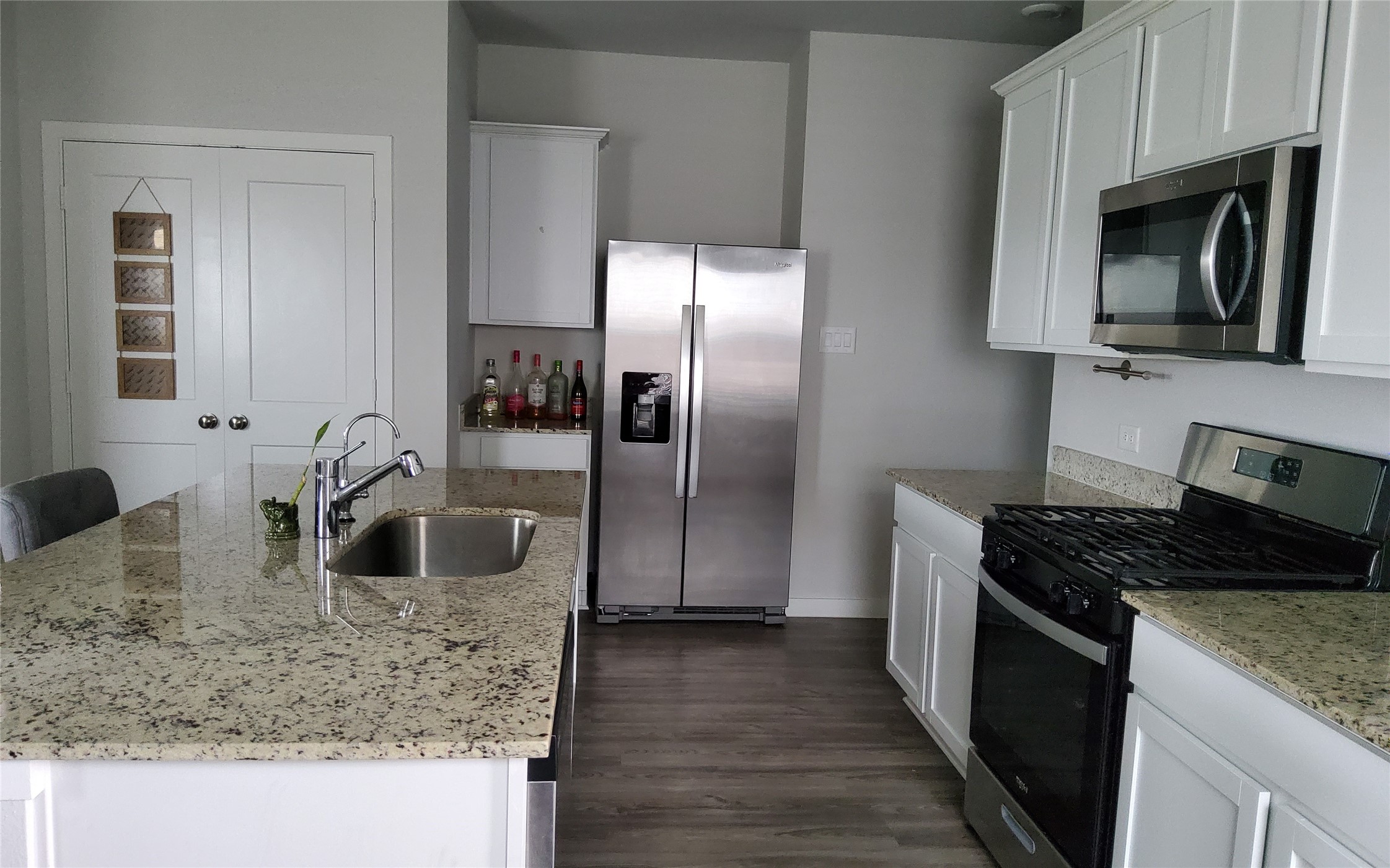 17359 King Eider Road Waller, TX 77484 - Photo 12 of 22 a kitchen with granite countertop a sink stove and refrigerator