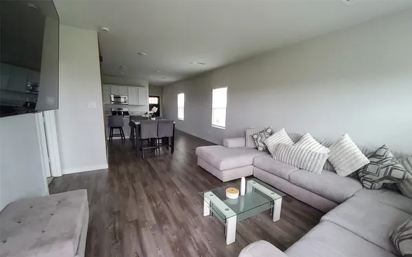 a living room with furniture and a wooden floor