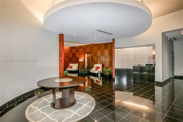 a dining room with furniture and a floor to ceiling window