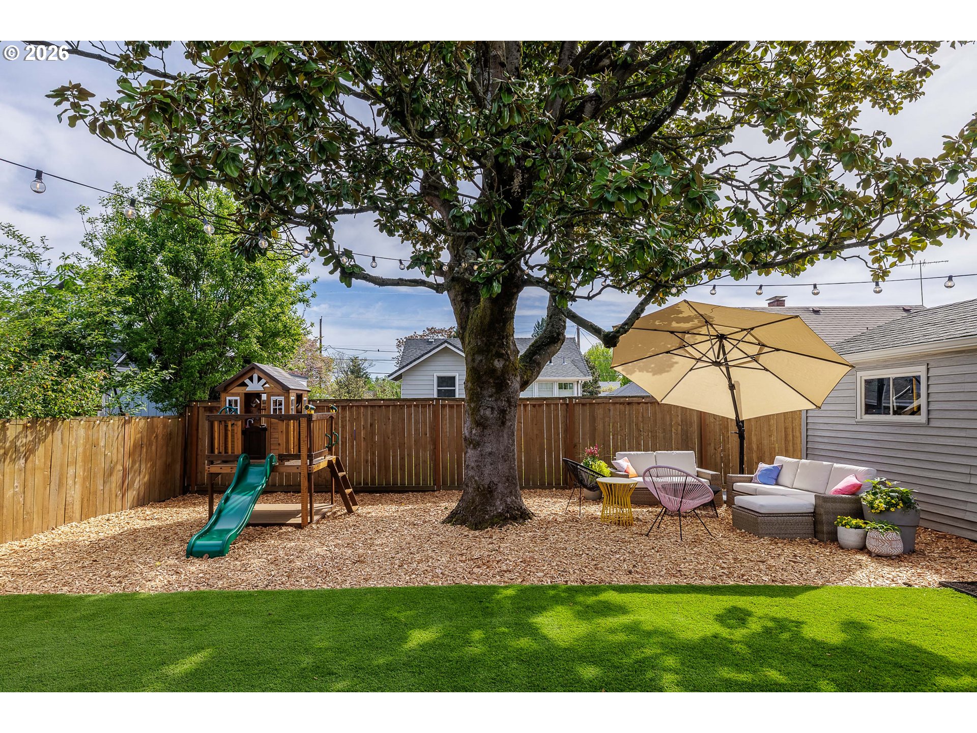 6128 North Denver Avenue Portland, OR 97217 - Photo 29 of 32 a view of a backyard with table and chairs under an umbrella