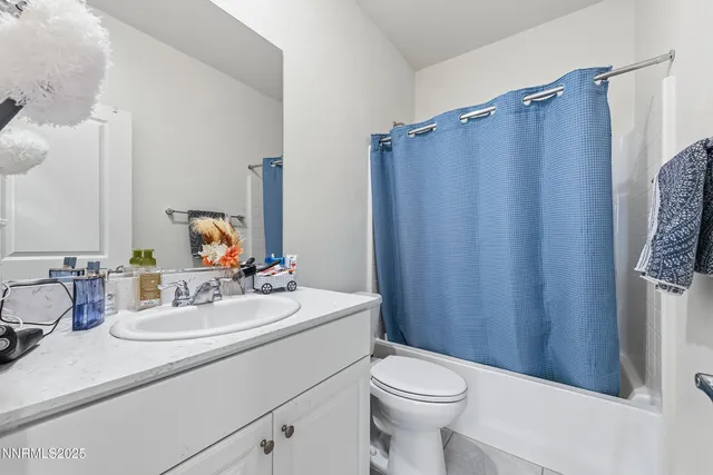 a bathroom with a sink a toilet a mirror and shower curtain