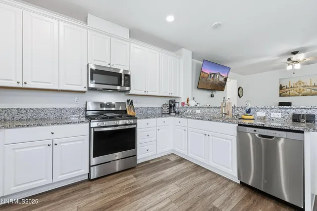 a kitchen with stainless steel appliances granite countertop a stove a sink and a microwave