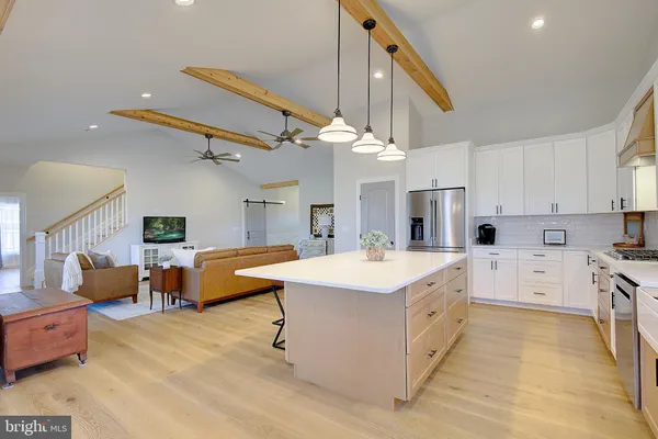 a large white kitchen with cabinets a sink and a stove