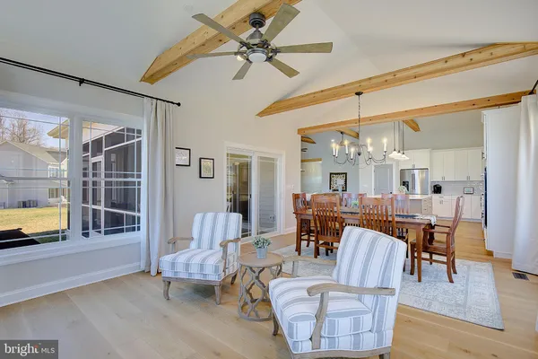 a dining room with furniture a chandelier and wooden floor