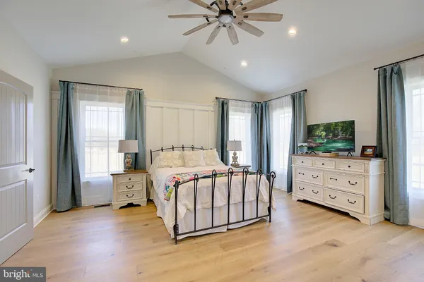 a spacious bedroom with a bed and a ceiling fan