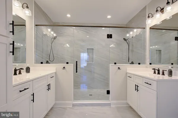 a bathroom with a double vanity sink mirror and shower