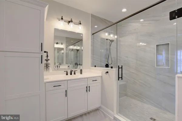a bathroom with a double vanity sink mirror and shower