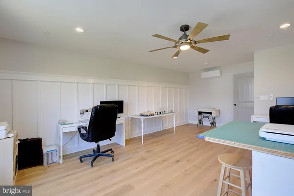 a workspace with furniture and a ceiling fan
