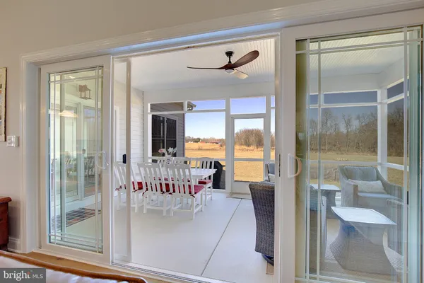 a dining room with furniture and a large window