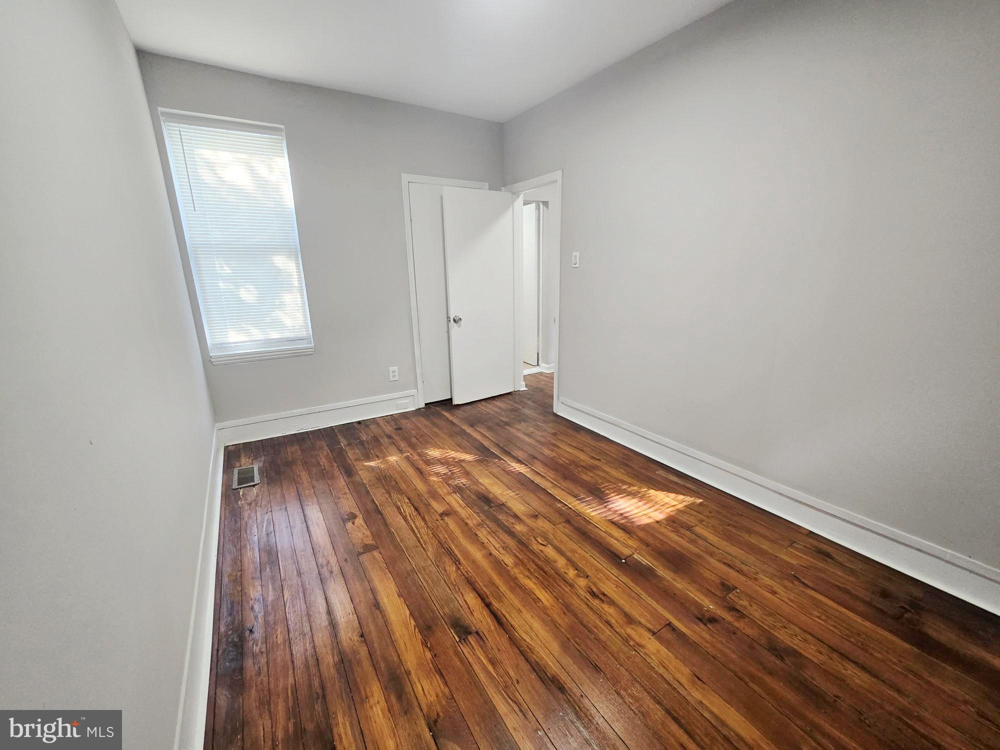 1910 Sigel Street Philadelphia, PA 19145 - Photo 17 of 25 a view of an empty room with wooden floor and a window