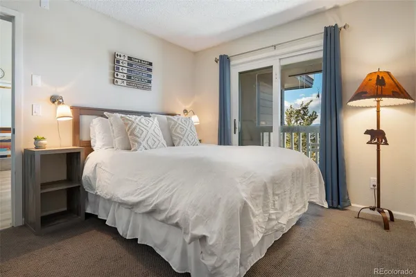 a bed sitting in a bedroom next to a bathroom
