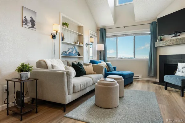 a living room with furniture a flat screen tv and a fireplace