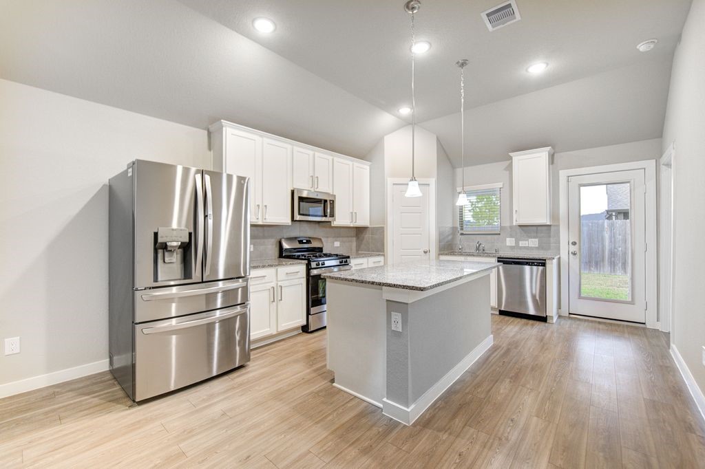 17692 Tree Of Heaven Conroe, TX 77385 - Photo 15 of 50 Take a look at this spacious and bright kitchen with pendant lights.