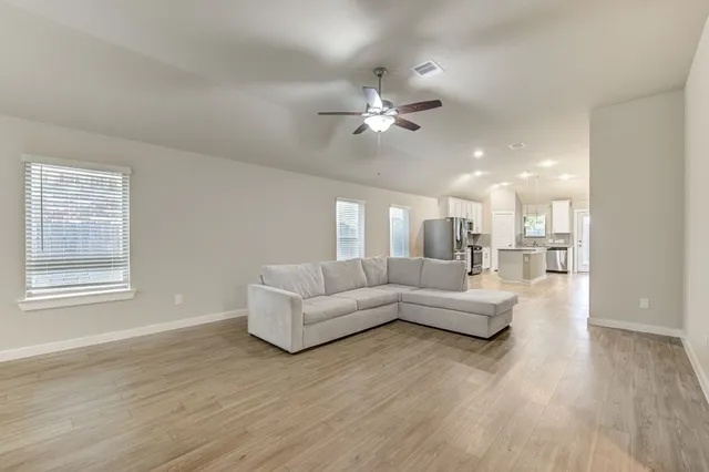 a living room with furniture and a wooden floor
