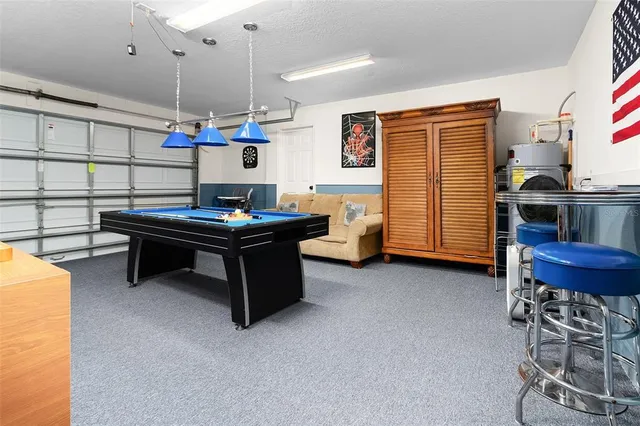 a kitchen with kitchen island a stove a refrigerator and a dining table with wooden floor