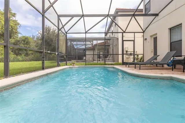 a swimming pool with a yard and glass windows