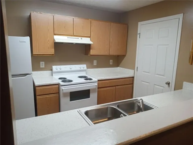 a kitchen with a cabinets and white appliances