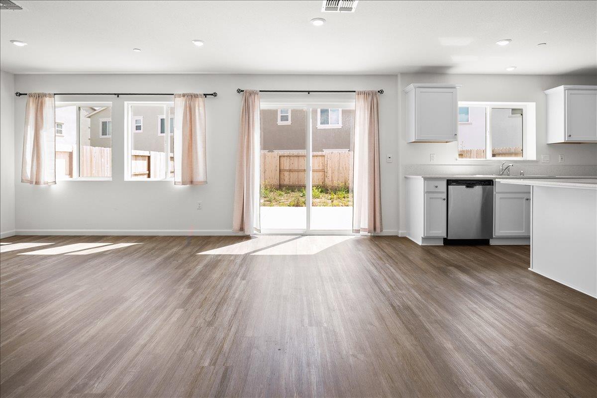 18462 Waterfront Way Lathrop, CA 95330 - Photo 15 of 50 a view of a kitchen with a fridge wooden floor and a window
