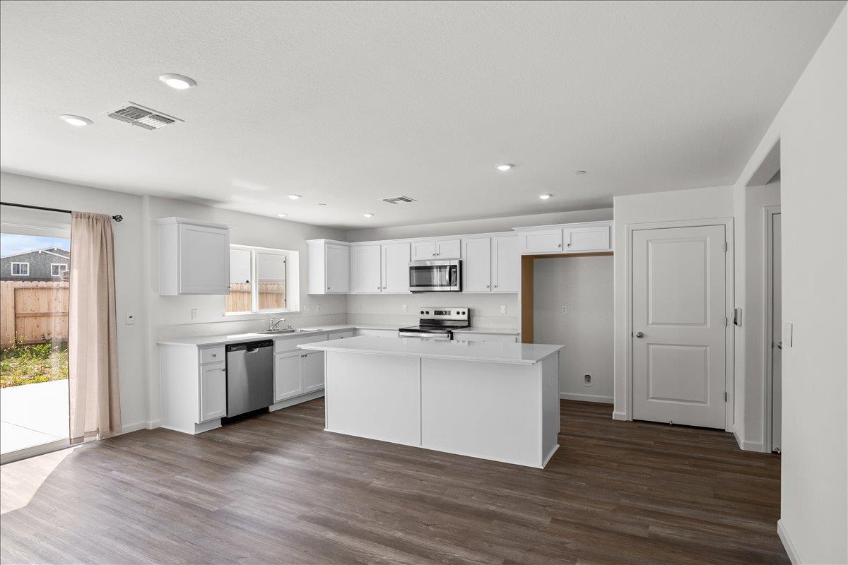 18462 Waterfront Way Lathrop, CA 95330 - Photo 16 of 50 a kitchen with a sink and a refrigerator