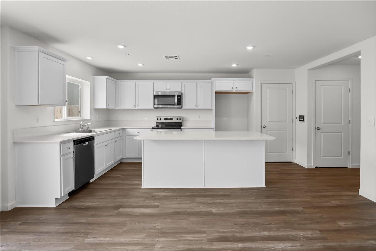 18462 Waterfront Way Lathrop, CA 95330 - Photo 6 of 50 a large kitchen with stainless steel appliances granite countertop a stove a sink dishwasher and a refrigerator
