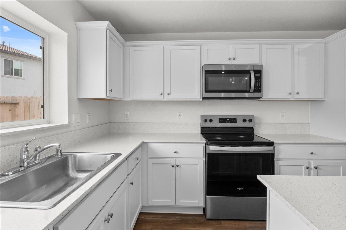 18462 Waterfront Way Lathrop, CA 95330 - Photo 7 of 50 a kitchen with white cabinets and a stove top oven