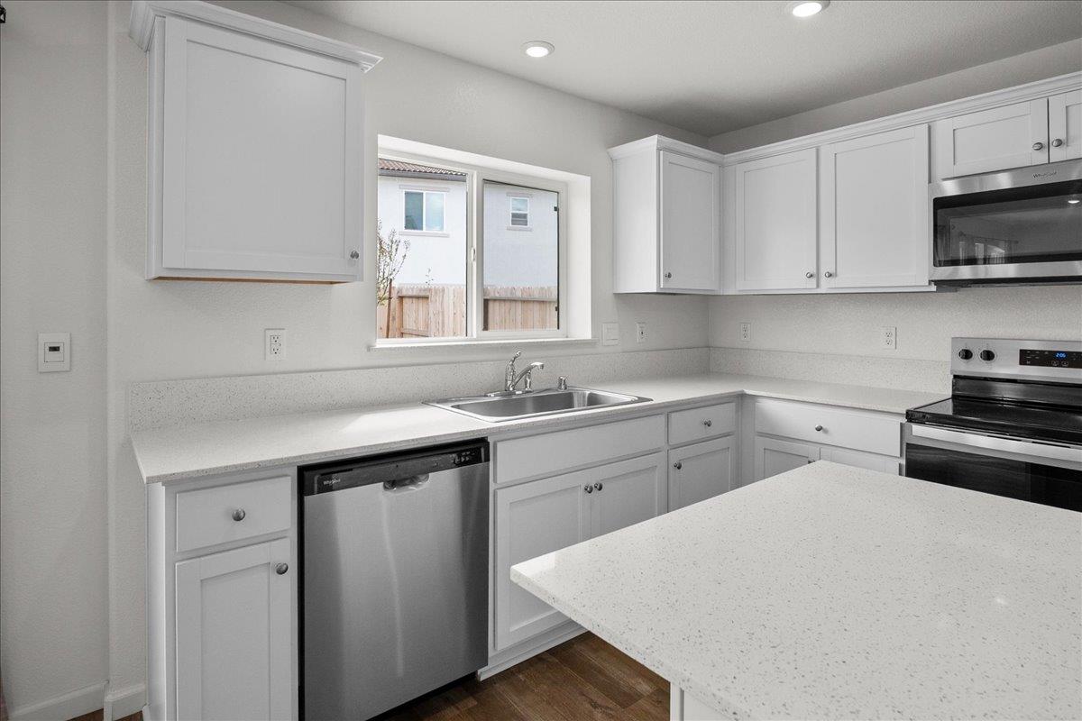 18462 Waterfront Way Lathrop, CA 95330 - Photo 8 of 50 a kitchen with white cabinets appliances and a window