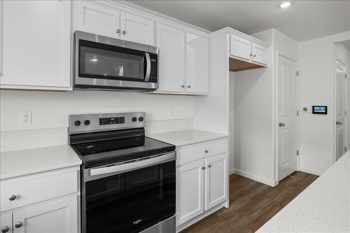 18462 Waterfront Way Lathrop, CA 95330 - Photo 9 of 50 a kitchen with cabinets stainless steel appliances and wooden floor