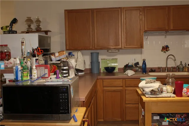 a kitchen with a sink a stove and cabinets
