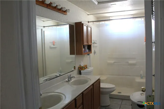 a room with lots of books and a refrigerator