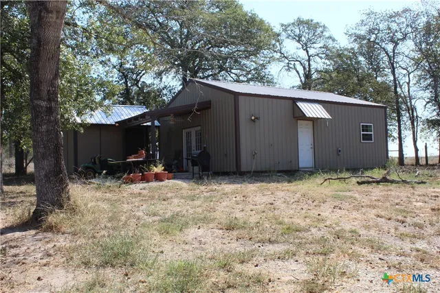 a view of a house with a yard and tree