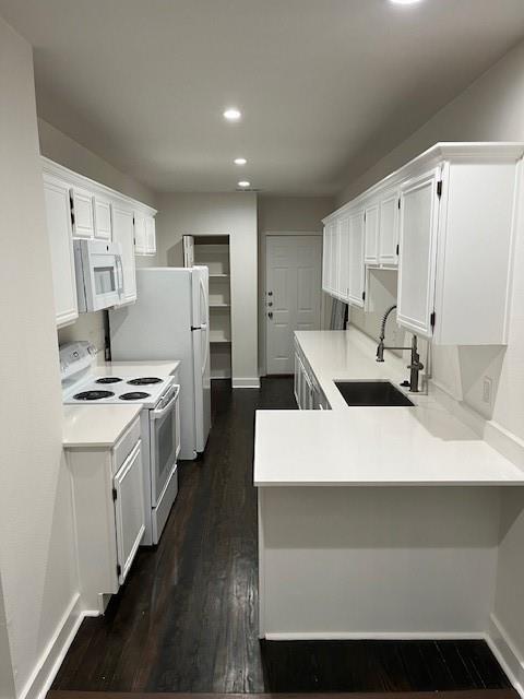 a large white kitchen with wooden floor