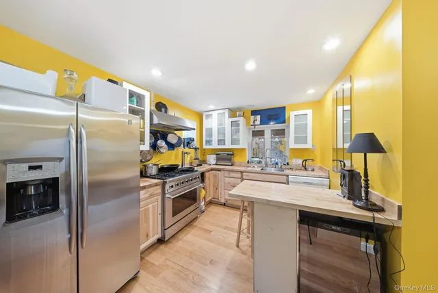a kitchen with stainless steel appliances granite countertop a sink a stove and a refrigerator