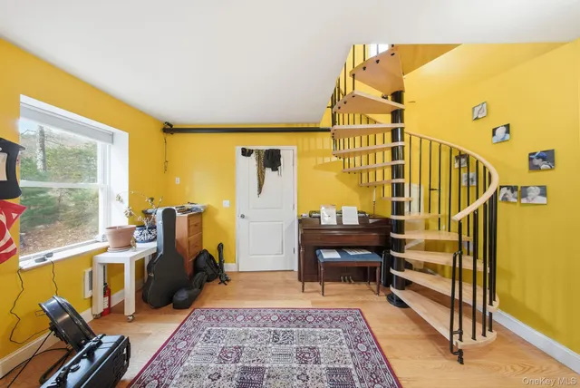 a view of a hallway with wooden floor and a bathroom