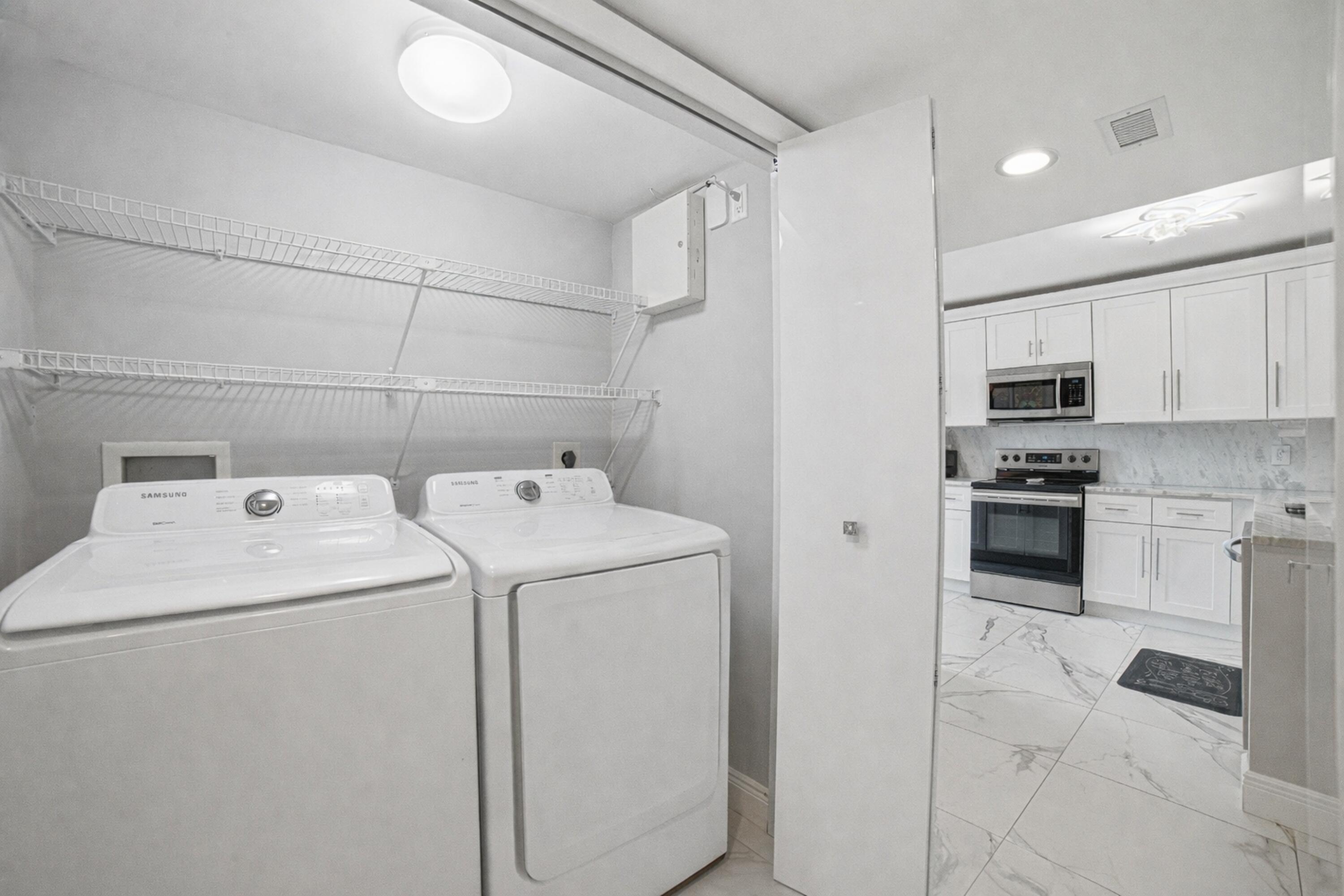 6149 Pointe Regal Circle, Unit 104 Delray Beach, FL 33484 - Photo 29 of 64 a view of storage and utility room with washer and dryer
