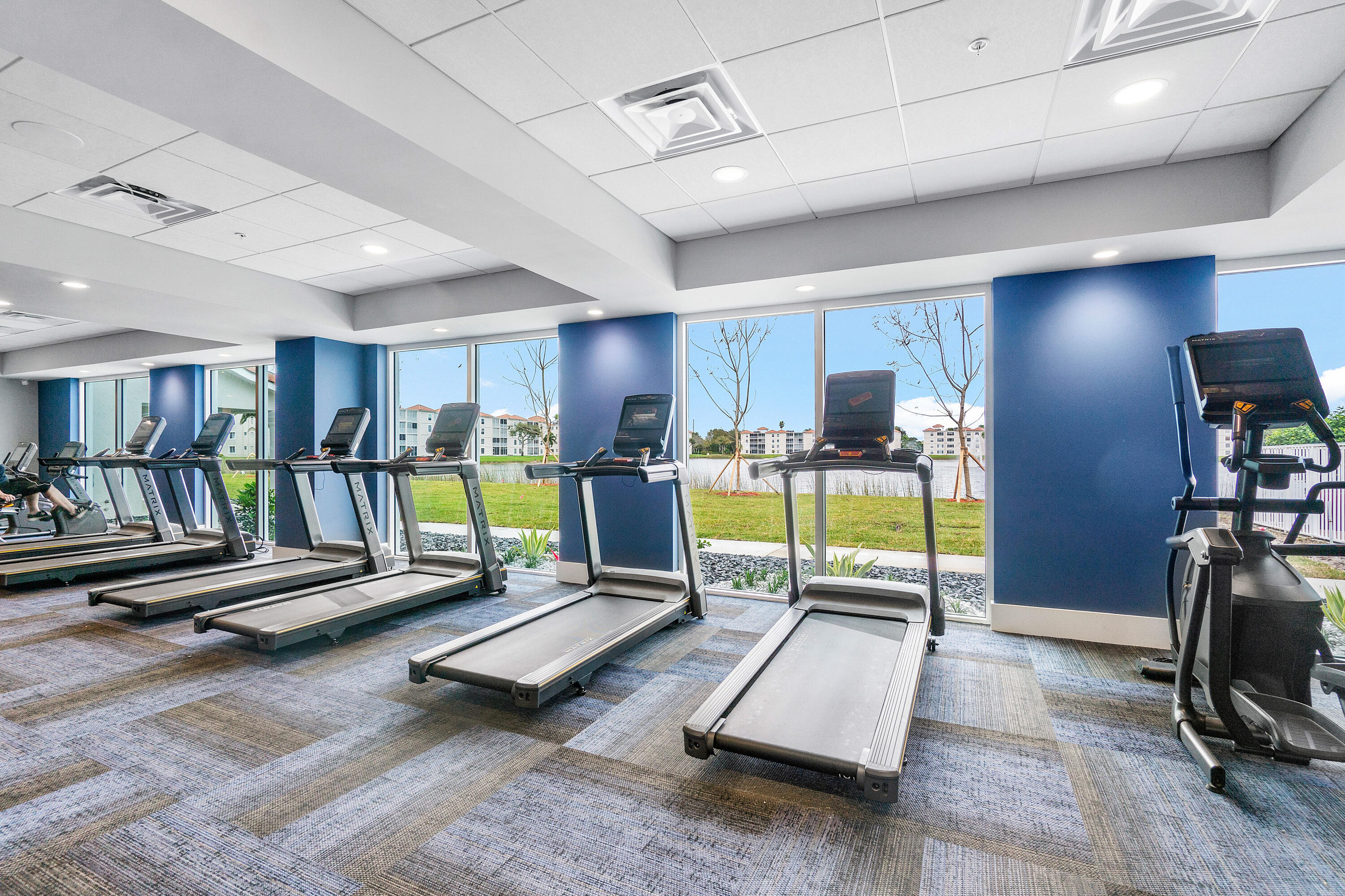 6149 Pointe Regal Circle, Unit 104 Delray Beach, FL 33484 - Photo 42 of 64 a living room with gym equipment and a table