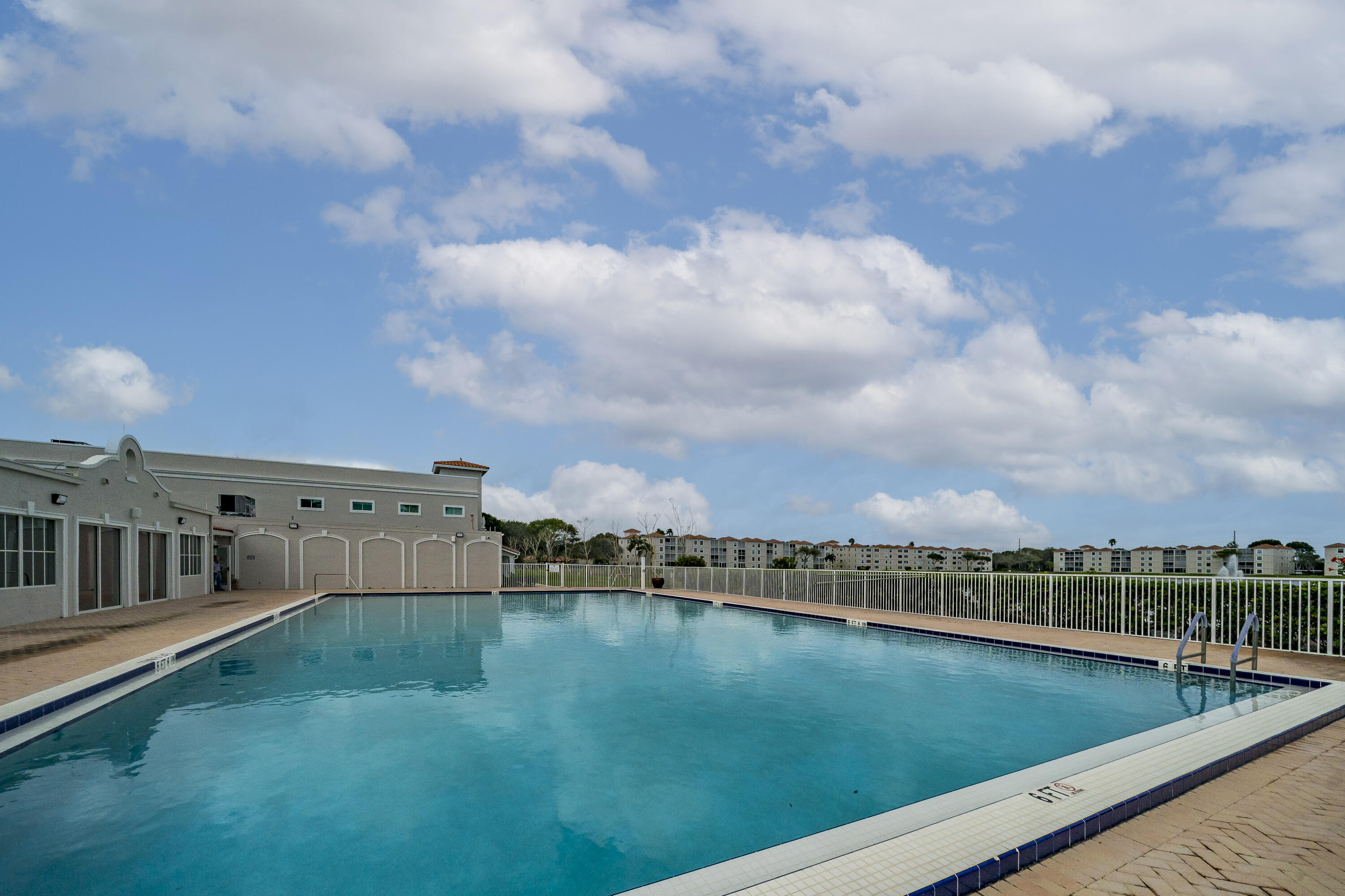 6149 Pointe Regal Circle, Unit 104 Delray Beach, FL 33484 - Photo 54 of 64 a view of a swimming pool with an outdoor seating and a yard
