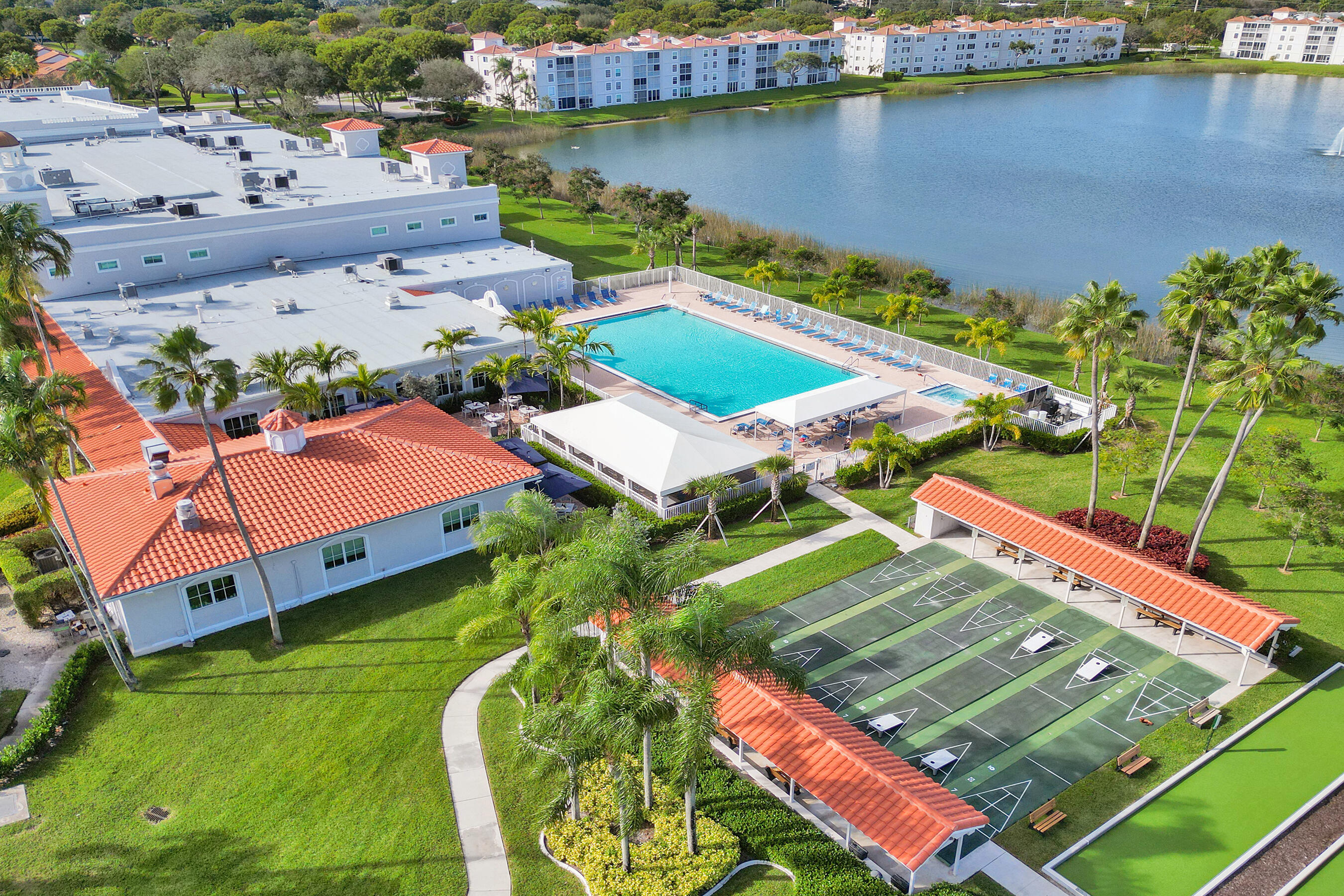 6149 Pointe Regal Circle, Unit 104 Delray Beach, FL 33484 - Photo 60 of 64 an aerial view of a pool yard lake and outdoor seating