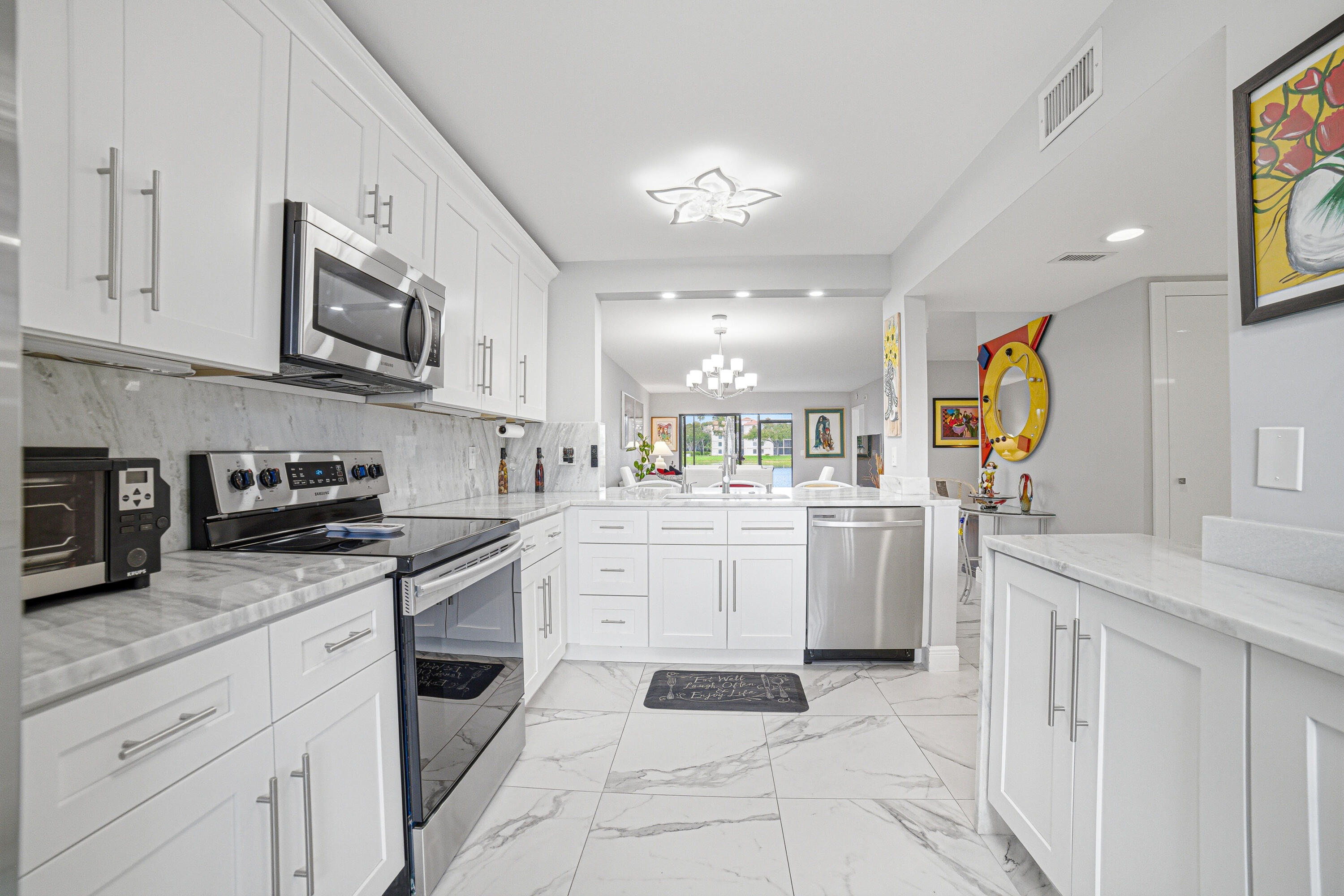 6149 Pointe Regal Circle, Unit 104 Delray Beach, FL 33484 - Photo 8 of 64 a kitchen with cabinets and window